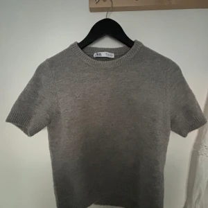Grå kortärmad tröja från Zara - Säljer en grå kortärmad stickad tröja från Zara. Skriv om ni är intresserade. Pris kan diskuteras. 