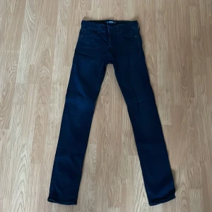 Mörkblå slim jeans från Jack & Jones - Snygga mörkblå slim jeans från Jack & Jones, modell Slim/Glenn. Klassisk femficksdesign med knappgylf och bälteshällor. Perfekta för en stilren look. Knappt använda. 
