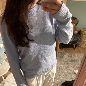 Ljusblå stickad tröja - Mysig ljusblå stickad tröja med rund hals och långa ärmar. Perfekt för kyligare dagar och ger en avslappnad stil. Passar bra till både jeans och kjol.