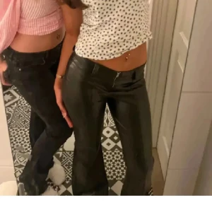 Svarta bootcut skinn byxor  - Snygga svarta bootcut-byxor i skinnmaterial, Perfekta för en trendig look med en glansig finish. Passar bra till både vardag och festliga tillfällen. Helt nya endast testade,från Gina Young men passar mig i längd som är 168 och i storlek o jag bär xs/s - 32/34