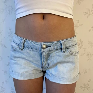 Ljusblå jeansshorts  - Snygga ljusblå jeansshorts med klassisk femficksdesign och knappgylf. Perfekta för varma sommardagar. De har en låg midja och är tillverkade i ett bekvämt denimtyg. Kolla gärna in mina andra jeansshorts💕Jeansshortsen passar även ifall man har storlek S. Midjemått tvärsöver är ca 39cm