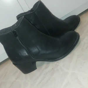 Svarta boots med dragkedja - Snygga svarta boots från ten points, i skinn med dragkedja på sidan. De har en låg klack och en stilren design som passar perfekt till både jeans och klänning. Perfekta för höst och vinter!