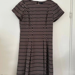 Figursydd klänning från Stockh LM - Superfin kortärmad figursydd och fodrad mönstrad klänning från STOCKH LM i storlek 40. Fina insydda detaljer och dold dragkedja bak. Nyskick. Nypris 799:-. Perfekt till kontoret eller cocktail-partyt. Eller ja, till vad som helst.   Hämtas i Stockholm eller skickas mot porto. 