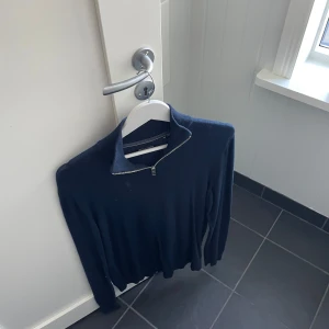 Mörkblå tröja med dragkedja från Jack & Jones - Säljer en stilren mörkblå tröja från Jack & Jones med dragkedja vid halsen. Perfekt för en avslappnad look. Tröjan har långa ärmar och är tillverkad i ett mjukt material. Väldigt tunn och skön tröja som passar överallt och sitter väldigt bekvämt. 