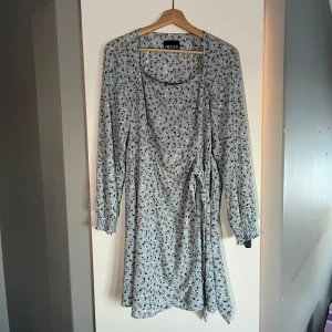 Blommig klänning från Pieces - Söt blommig klänning från Pieces (vero moda)  i ljusblått med små blommor i rosa och grönt. Klänningen har långa ärmar och ett knytband i midjan för en fin passform. Perfekt för vår och sommar! Storlek M, använd några få gånger men jättefin till sommaren🩷 Nypris 500 