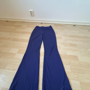 Blå byxor från Nelly - Snygga blå byxor från Nelly i storlek XS. Byxorna har en hög midja och en wide stil som ger en trendig look. Perfekta för att skapa en stilren outfit.