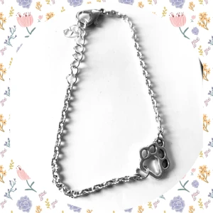 By prisförslag- Silverarmband med tassmotiv - Snyggt silverarmband med ett charmigt tassmotiv. Armbandet har en justerbar kedja och ett klolås för enkel användning. Perfekt för djurälskare som vill ha en subtil men stilren accessoar.