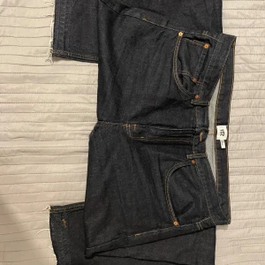 Mörkblå jeans - Snygga mörkblå jeans från 157 med klassisk femficksdesign och orange sömmar. Perfekta för en avslappnad stil. De har en rå kant vid benen för en trendig look.