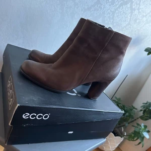 Bruna boots från Ecco - Snygga bruna boots från Ecco med klack och dragkedja. Perfekta för höst och vinter. Tillverkade i skinn för en stilren look.