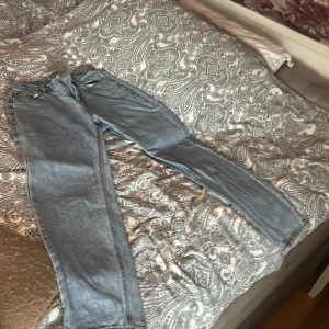 Blå jeans från RYVLS - Snygga blå jeans från RYVLS med klassisk femficksdesign. De har en straight passform och är tillverkade i slitstarkt denim. Perfekta för en avslappnad stil.