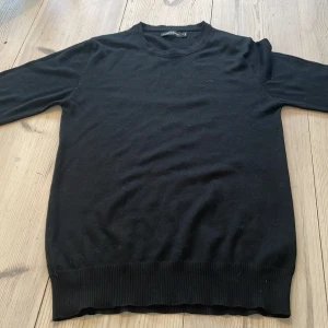 Svart tröja från J.Lindeberg - Säljer en stilren svart tröja från J.Lindeberg. Tröjan har långa ärmar och en klassisk rund halsringning. Perfekt för en minimalistisk look.