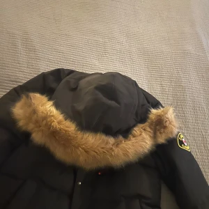 Svart dunjacka med päls från Canada - Svart Zavetti Canada dunjacka med pälskrage storlek M