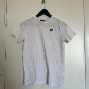 Vit t-shirt - Vit t-shirt från Lyle & Scott med deras ikoniska logga på bröstet. Kortärmad och tillverkad i bomullsmaterial. Unisex, stor i storleken