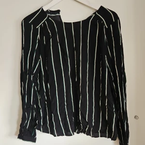 Randig blus - Svart blus med gröna/vita ränder.