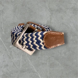 Randigt flätat bälte med läderdetaljer - Snyggt flätat bälte i blått och beige med bruna läderdetaljer. Bältet har ett stilrent silverfärgat spänne och är perfekt för att ge en casual look en extra touch. Passar bra till jeans eller chinos.