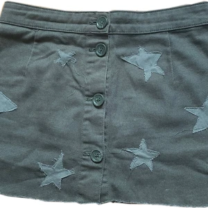 Grön kjol med diy stjärndetaljer - Snygg grön miniskirt / kortkjol med knappar framtill och coola diy stjärnapplikationer. 35 cm midja 30 cm längd