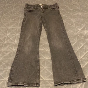 Grå jeans från Gina Tricot - Snygga grå jeans från Gina Tricot i storlek 152. De har en klassisk femficksdesign med knapp och dragkedja framtill. Byxorna har en bootcut-stil som ger en trendig look.