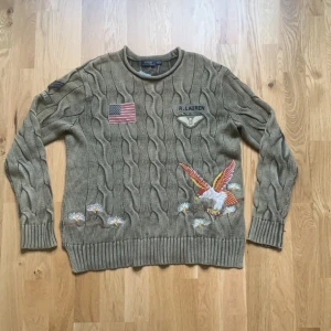 Ralph lauren army cable knit - Fräsch ralph lauren cable knit i army grön färg. Den har broderier och patches på både fram och baksida. Tröjan är i storlek M men passar lite mindre. Skriv om ni vill ha fler bilder eller om ni har frågor!