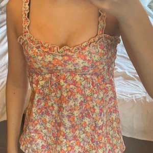 Blommig topp - Super gullig topp som var längre förut men jag sydde den kortare. Den har använts ungefär tre gånger och är i väldigt bra skick. Skriv gärna om du vill att jag skickar fler bilder på toppen.