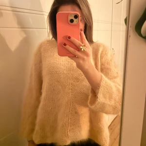 Beige stickad tröja - Säljer denna tröja som är köpt av en tjej som stickar egna kläder. Tröjan är i storlek S. Det är en mysig beige stickad tröja i oversized stil. Perfekt för höst och vinter. Tröjan har långa ärmar och en enkel design som gör den lätt att matcha med olika outfits. Superbekväm och varm! 
