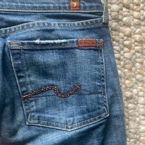 Bootcut jeans - Säljer nu ett par supersnygga bootcut jeans köpta i USA. Jeansen har strass på bakfickorna i orange färg. Väl använda men bra skick💓. Orginal pris 2500.