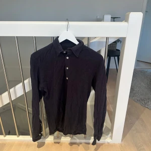 Marinblå långärmad skjorta - Säljer en stilren marinblå långärmad skjorta i bra skick. Den har knappar hela vägen ner och en klassisk krage. Perfekt för både vardag och fest. Passar bra till jeans eller kostymbyxor.