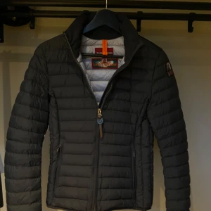Svart pufferjacka från Parajumpers - Säljer en snygg svart pufferjacka från Parajumpers i mycket bra skick. Jackan har en dragkedja framtill och en hög krage för extra värme. Perfekt för höst och vinter! Den är normal i passformen och har långa ärmar. En stilren och praktisk jacka för kyliga dagar.