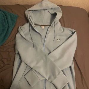 Lacoste Hoodie/Kofta - Säljer min Lacoste tröja då jag inte använder den längre men den är väldigt bekväm och varm