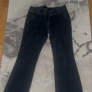 Lågmidjade flare jeans i storlek 4 vilket motsvarar 32 men de är stora i storlek så skulle säga de passar mer någon som har 34/36. Saknar knapp men skickar med en knapp man kan sy på, har annars annat sätt att knäppa. Inga fläckar och felfria annars. 