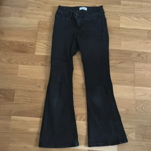 Svarta bootcut jeans från Lindex - Säljer ett par svarta bootcut jeans från Lindex i storlek EUR 134. De har en klassisk femficksdesign. Jeansen är i bra skick och har en snygg passform som ger en retro touch till din outfit.