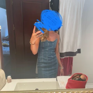 Jeansklänning i tight passform - Snygg jeansklänning i tight passform som sitter perfekt för en utekväll eller fest. Axelbandslös design med en klassisk blå denimfärg. Klänningen är kort och framhäver figuren på ett stilrent sätt. Perfekt för sommarens alla tillfällen! Använd 2 gånger 