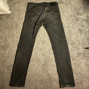 Lee slimfit jeans  - Jeans från märket Lee. Modellen heter Powell och sitter slimfit. Sitter som 32 i midjan. Skicket är bra men tecken på användning men det gör en snygg vintage look.  Hör av dig om fler funderingar eller frågor.