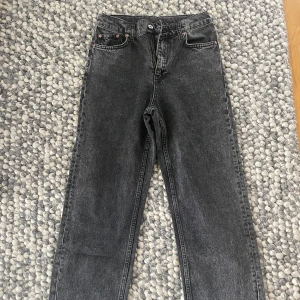 Svarta jeans med slits - Säljer ett par snygga svarta jeans i mycket bra skick. De har en cool slitsdetalj vid benen. Jeansen är från Grunt. Storlek 26