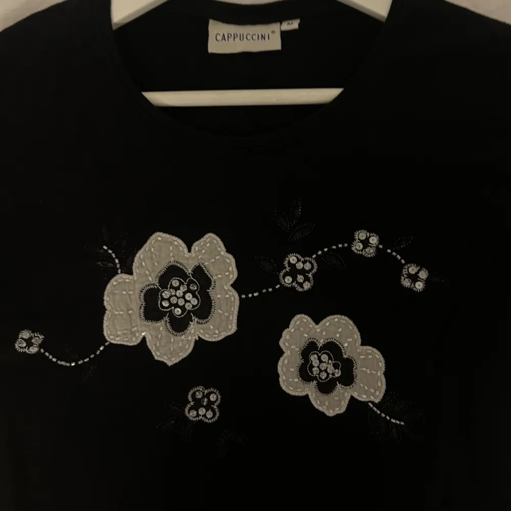 Säljer den här söta T-shirten! Blommorna har pärlor och paljetter på sig 💓. T-shirts.