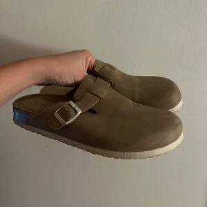 Birkenstockliknade skorn från märket Duffy  - Skor likande birkenstock modellen Boston. Färgen är beige/brun. Storleken är en liten 39 (jag brukar ha 37)  Använda 1 gång. Säljer pågrund av platsbrist. Nypris: 600 kr 