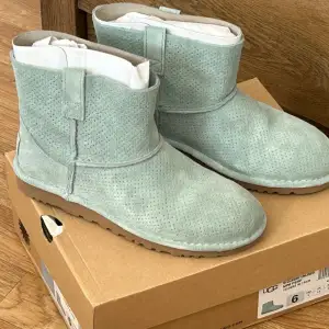 Säljer ett par supermysiga ljusblå UGG boots i mocka. De har en klassisk design med rund tå och en bekväm sula. Perfekta för att hålla fötterna varma under hösten och vintern. De är i storlek 6 och kommer i originalkartong. Helt nytt 