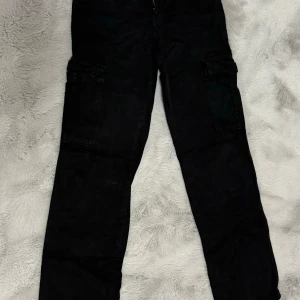 Svarta cargopants - Säljer ett par svarta cargopants i bra skick. De har flera praktiska fickor och en bekväm passform. Perfekta för en avslappnad stil eller vardagsäventyr.