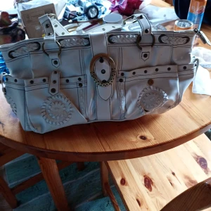 Vintage stor rymlig hanväska med många detaljer skinn, 48 cm lång - Vintage stor och rymlig vit handväska med handtag  o detaljer utanpå väskan ,fickor utanpå och inne i väskan. Mycket finy skick.