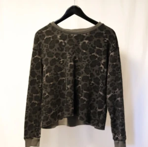 Brun leopardmönstrad tröja - Säljer en brungrå tröja med leopardmönster. Den har långa ärmar och en avslappnad passform, perfekt för en chill dag. Tröjan är i ett mjukt material som känns skönt mot huden. Perfekt för höst och vinter!
