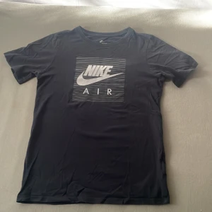 Svart Nike Air T-Shirt i storlek 147-168 - Detta är en svart Nike Air T-Shirt i storlek 147-158 mellan 12-13 år. Den har ett tryck på framsidan som är vit, och den är sällan använd. 