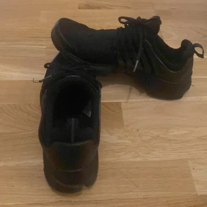 Nike presto  - Säljer ett par svarta Nike sneakers med snörning. Skorna har en stilren design med en diskret vit detalj på hälen. Perfekta för en sportig look, säljer ett par Nike presto de köptes för 1600kr och är knappt använda tveka inte på frågor eller prisförslag☺️