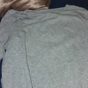 Grå långärmad tröja - Säljer en enkel och bekväm grå långärmad tröja. Perfekt för kyligare dagar och lätt att matcha med olika outfits. Tröjan har en klassisk design och är ett måste i garderoben. Passar bra på 11-12åringar