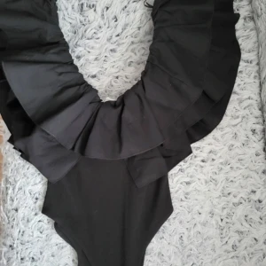 Svart body med volang från Zara - Snygg svart body från Zara med volanger 💗aldrig använd! Slutsåld