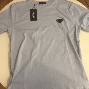 Ljusblå t-shirt från Prada - Snygg ljusblå t-shirt från Prada .