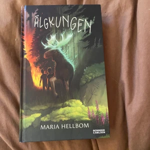Älgkungen - Boken 'Älgkungen' av Maria Hellbom, utgiven av Bonnier Carlsen, handlar om ett spännande äventyr i skogen där en magisk älg spelar en central roll. Perfekt för den som gillar mystik och natur.