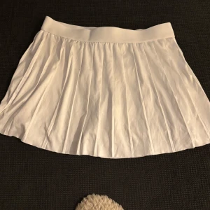 Vit tennisliknande kjol från weekday - Snygg tennisliknande kjol från weekday med stretchigt material och inbyggda shorts som passar till allt från XS-M. Skriv vid frågor pris kan diskuteras💗
