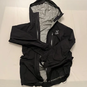 Svart vindjacka från Haglöfs - Säljer en svart vindjacka från Haglöfs i storlek XS. Jackan har en justerbar huva och där nere. Som ny! 