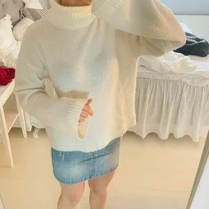 Vit stickad polotröja - Mysig vit stickad polotröja med långa ärmar och en hög krage. Perfekt för kyligare dagar och ger en stilren look. 