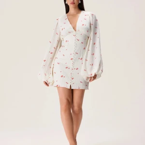 Adoore Kläning st 32 - Charmig vit klänning med knappar framtill. 