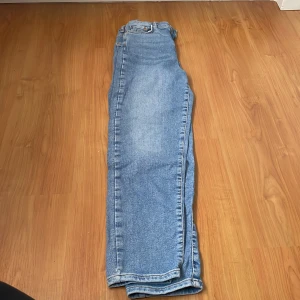 Blå jeans - Säljer ett par klassiska blå jeans med en rak passform. De har en traditionell femficksdesign och är perfekta för en avslappnad stil. Passar bra till både sneakers och kängor.